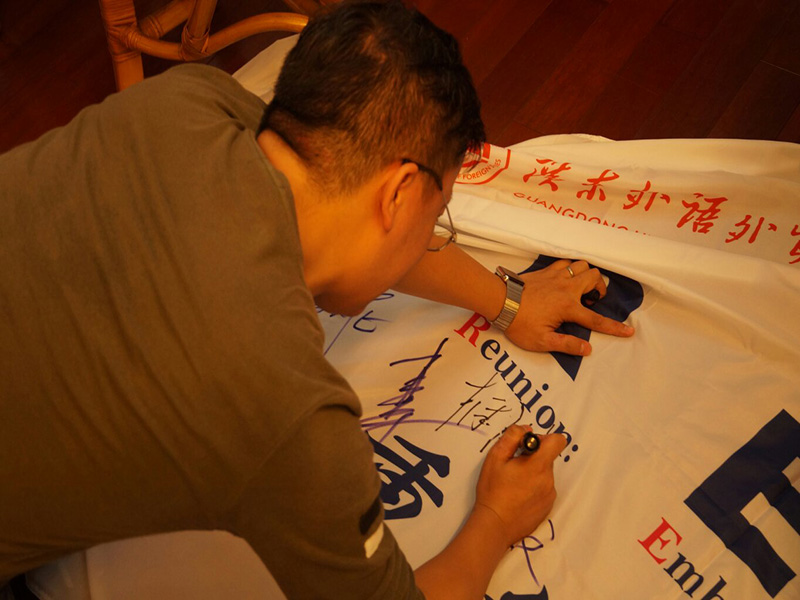 李国兴会长在云山勤工校友会会旗上签字祝福母校校庆